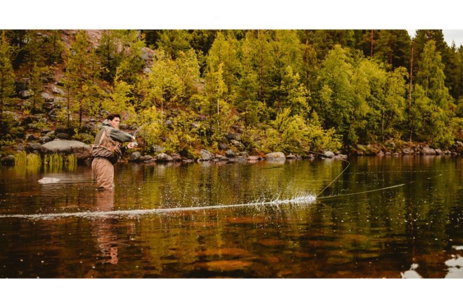Fisherman using rod fly fishing in mountain river